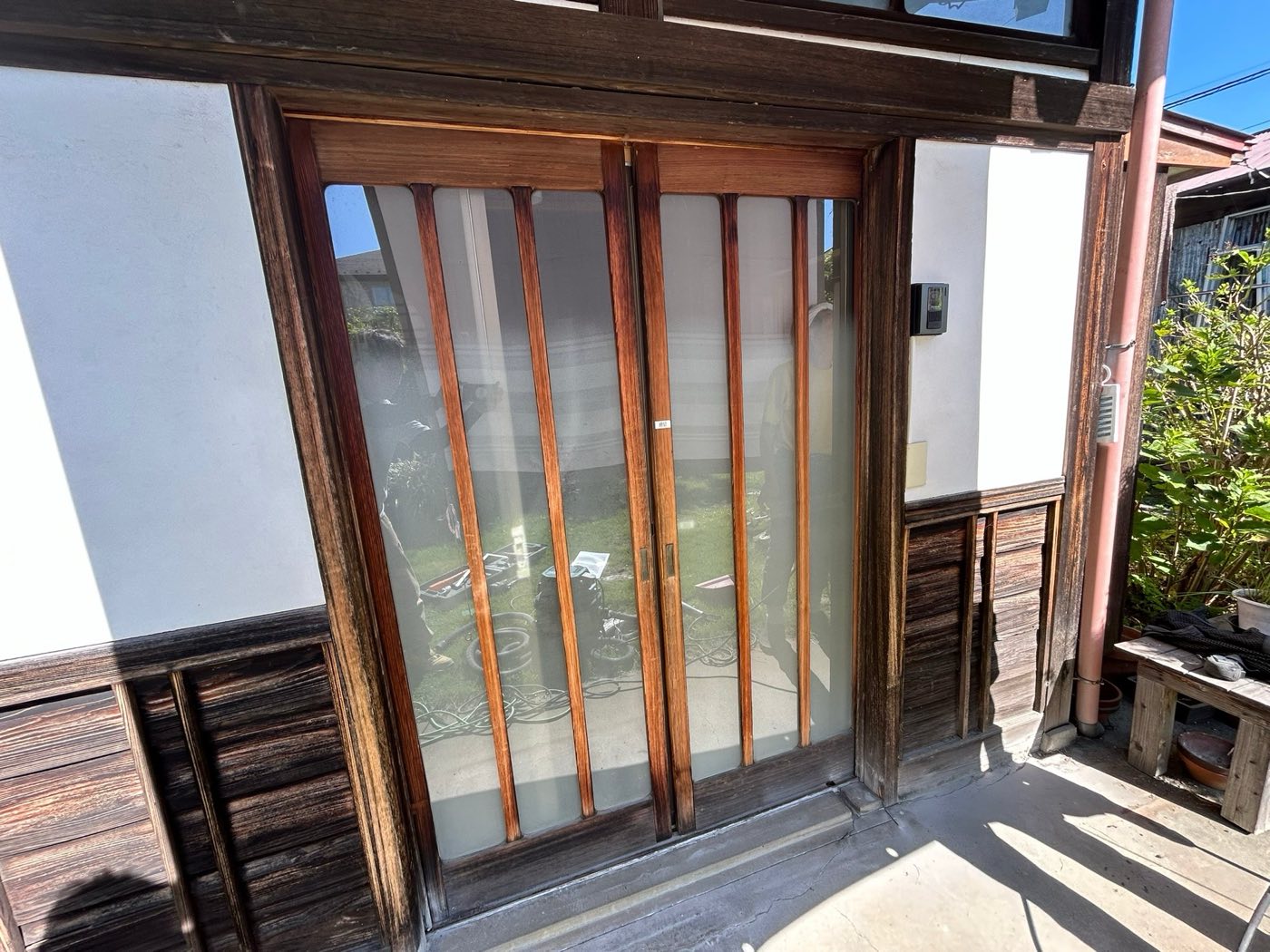 施工前の玄関。経年した木製の引き戸 / Before: the original weathered wooden sliding entrance doors