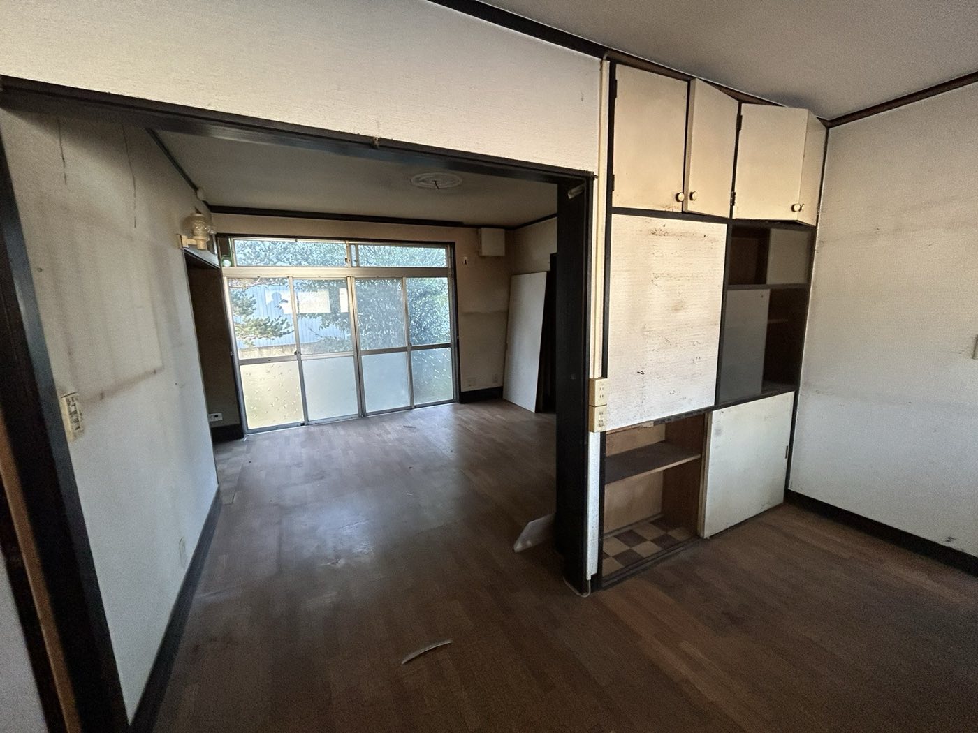 施工前のダイニングキッチン。経年した床と収納 / Before: the dining-kitchen before renovation